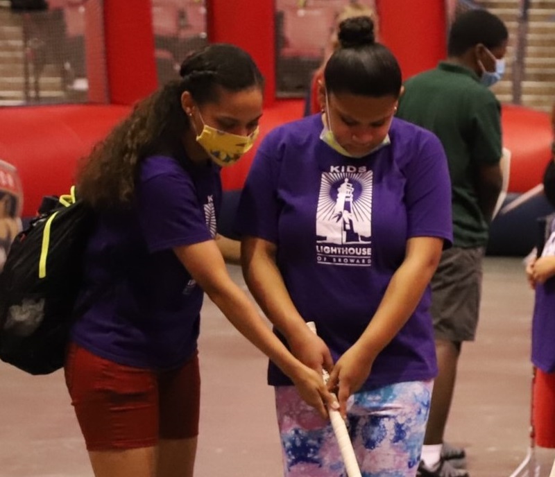 Instructor Saurym Quezada assists Alexiana Lopez
